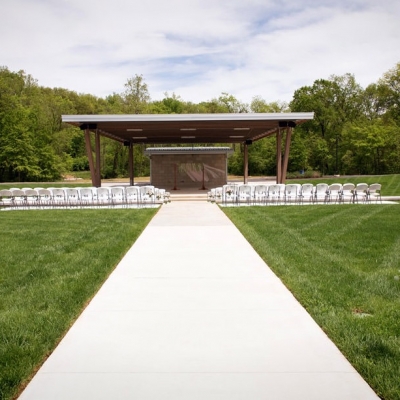White chairs are set up for an outdoor wedding at the Amphitheater