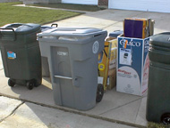 Boxes sitting next to trash cart.