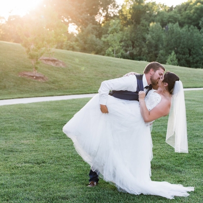 A groom sweeps his bride off her feet outside of O'Day Lodge