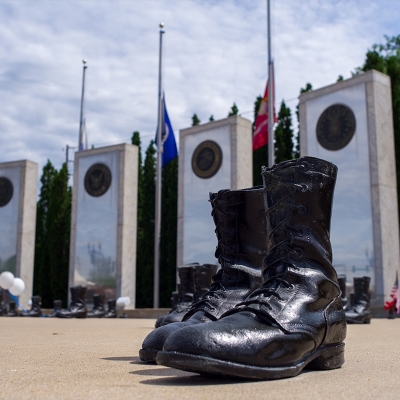 A platoon of bronze military boots are positioned as though marching in unison.