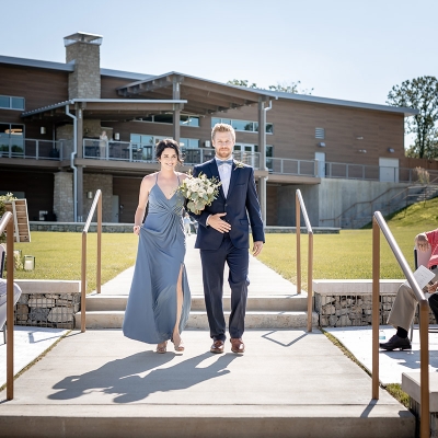 The Maid-of-Honor is led to the altar by a groomsman with O'Day Lodge as a backdrop.