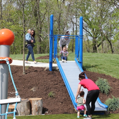 Moms take turns sending their children down a roller slide